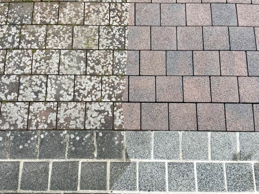 Gehweg zur Hälfte gereinigt: links flechtenbewachsen, rechts in rot-grauem Farbton